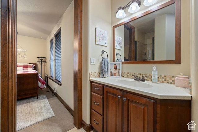 bathroom with tasteful backsplash, connected bathroom, vanity, and baseboards