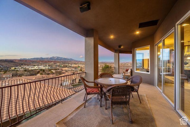 balcony at dusk featuring visible vents and a mountain view