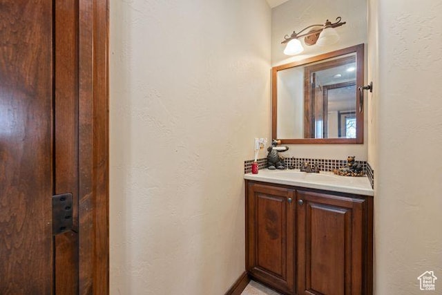bathroom with a textured wall and vanity