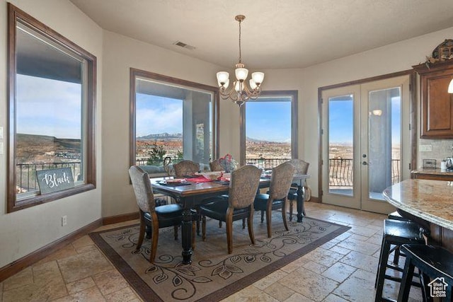 dining area with stone tile floors, visible vents, baseboards, french doors, and a notable chandelier