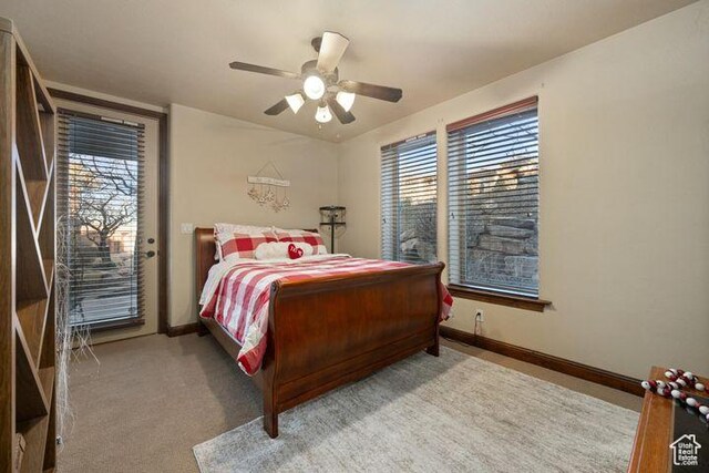 bedroom featuring access to exterior, multiple windows, light carpet, and baseboards