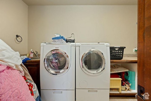 washroom with laundry area, independent washer and dryer, and a sink