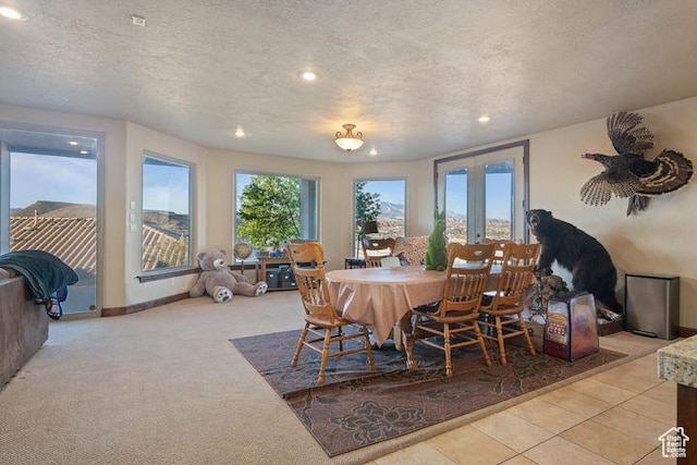 dining room featuring a healthy amount of sunlight, recessed lighting, a textured ceiling, and french doors