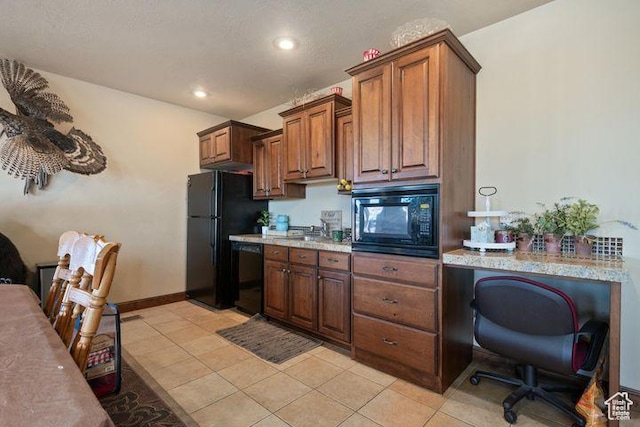 kitchen featuring light tile patterned floors, black appliances, and light stone counters
