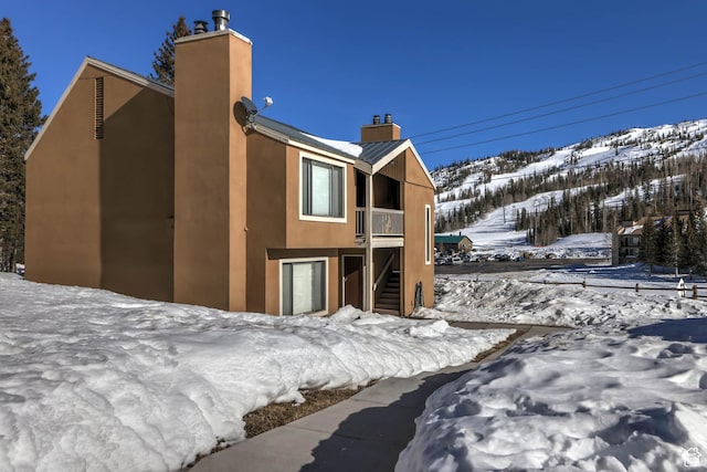 356 S S Hwy Unit A-1, Brian Head, UT 84719 - snow covered back of property featuring stairway, a chimney, and stucco siding