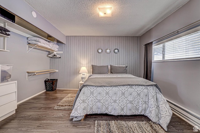 356 S S Hwy Unit A-1, Brian Head, UT 84719 - bedroom with wooden walls, baseboards, a baseboard radiator, wood finished floors, and a textured ceiling