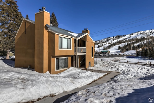 356 S S Hwy Unit A-1, Brian Head, UT 84719 - view of snowy exterior featuring a chimney, stairway, and a mountain view