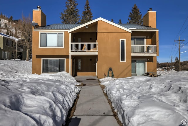 356 S S Hwy Unit A-1, Brian Head, UT 84719 - snow covered rear of property with metal roof, a chimney, a balcony, and stucco siding