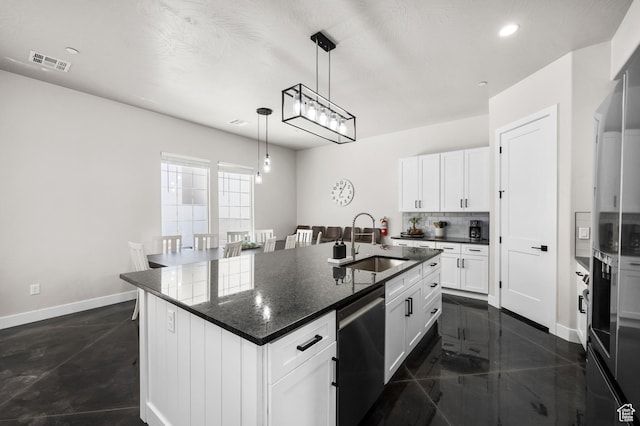kitchen featuring dishwasher, a kitchen island with sink, and white cabinetry