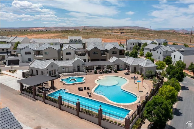 community pool with a residential view, fence, and a patio
