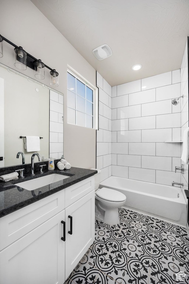 bathroom featuring toilet, visible vents, vanity, shower / washtub combination, and tile patterned floors