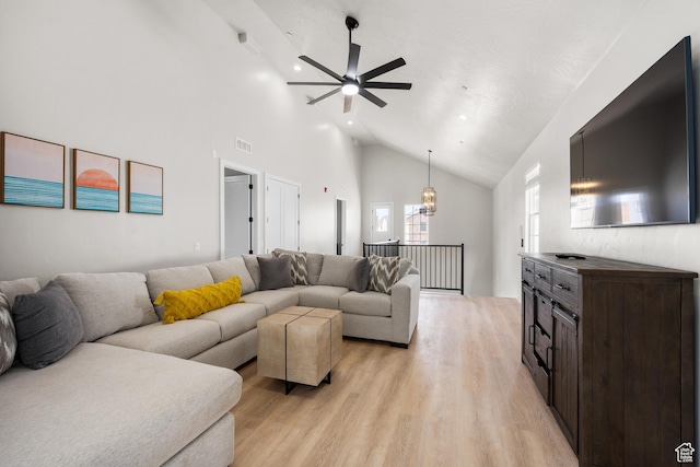 living area with light wood-type flooring, high vaulted ceiling, visible vents, and a ceiling fan