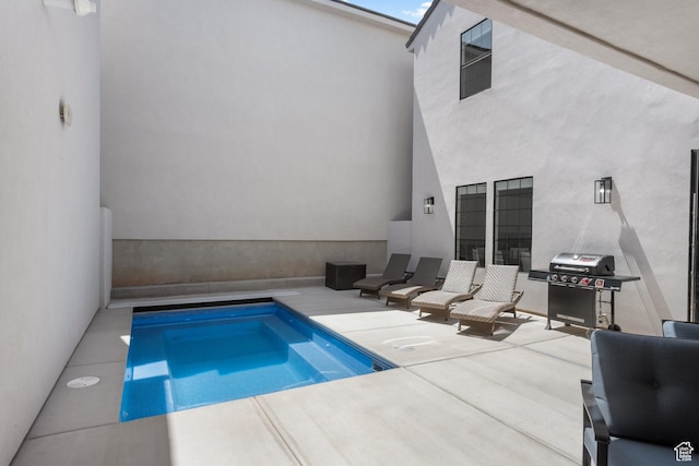 view of pool featuring a patio and a grill