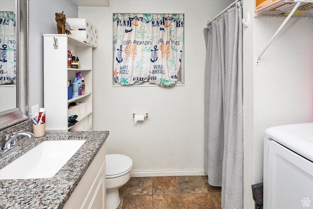 bathroom featuring toilet, baseboards, and vanity
