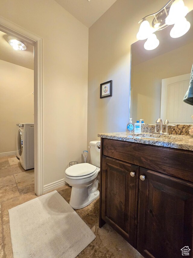 935 W 2100 N, Pleasant View, UT 84404 - bathroom featuring washer and dryer, toilet, vanity, a chandelier, and baseboards