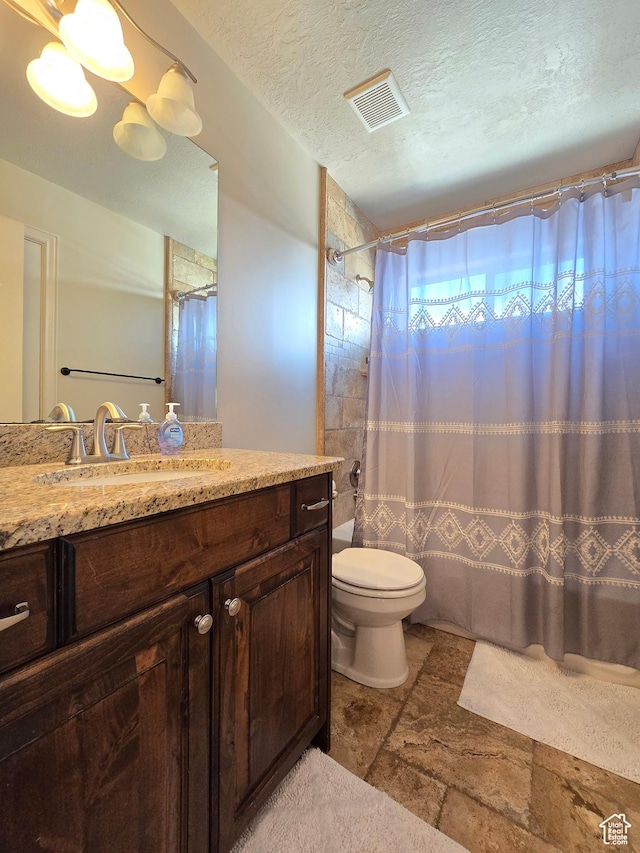 935 W 2100 N, Pleasant View, UT 84404 - bathroom featuring stone tile floors, toilet, vanity, curtained shower, and a textured ceiling