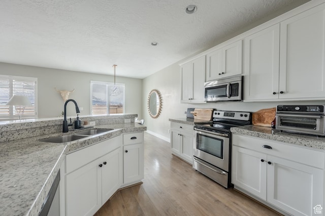 1863 S 900 E, Lehi, UT 84043 - kitchen with white cabinets, a toaster, stainless steel appliances, a sink, and light wood-type flooring