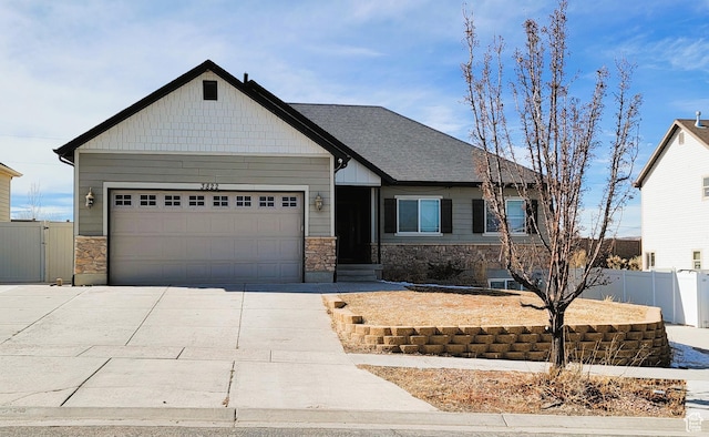 craftsman-style house with stone siding, driveway, a garage, and fence
