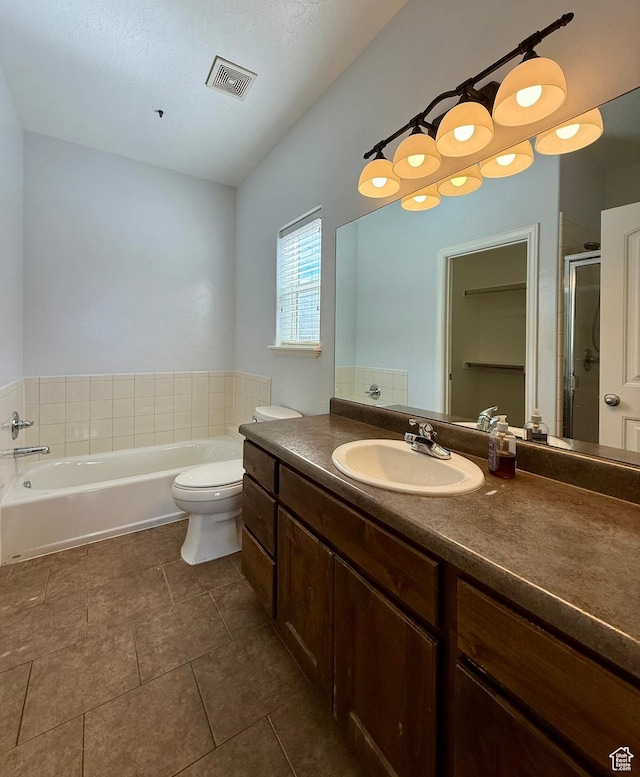 bathroom with visible vents, toilet, a stall shower, a bath, and vanity