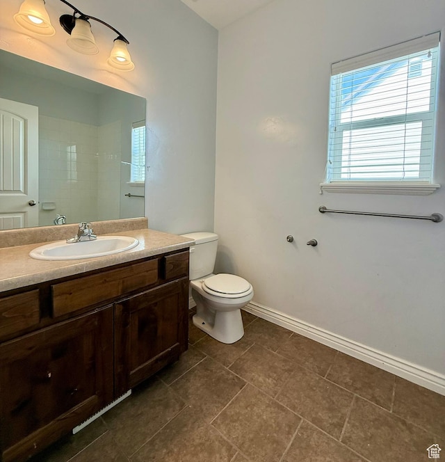 bathroom with vanity, toilet, and baseboards