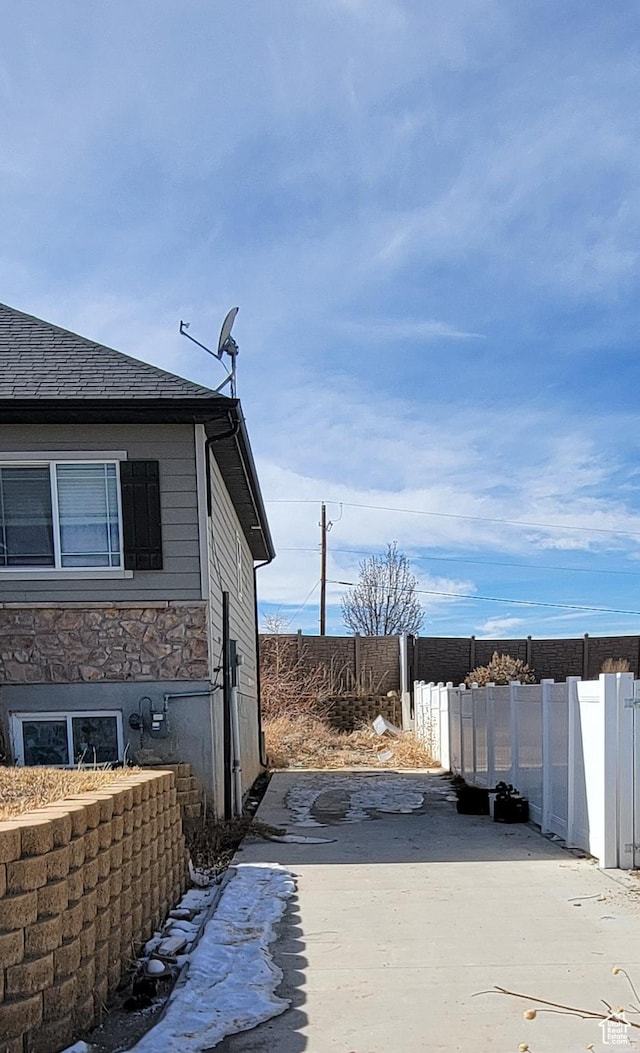 view of property exterior featuring fence and stone siding