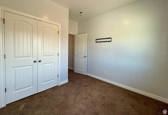 unfurnished bedroom featuring a closet, baseboards, and carpet