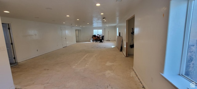 empty room with recessed lighting and unfinished concrete floors