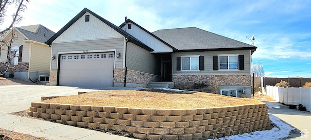 craftsman house with driveway, stone siding, fence, roof with shingles, and a garage