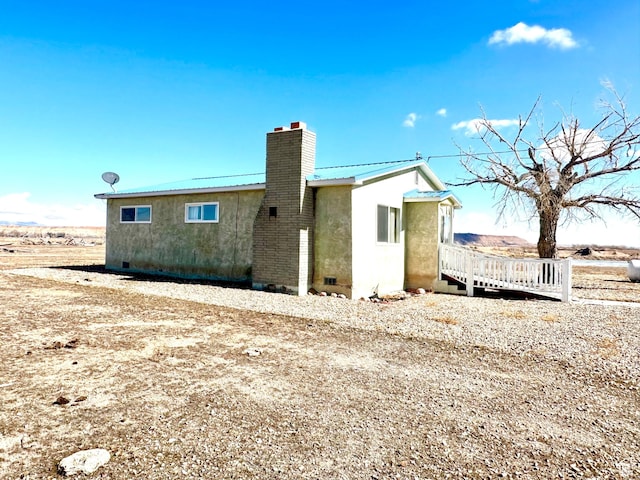 7998 E 5250 S, Randlett, UT 84063 - view of home's exterior with crawl space, a chimney, metal roof, and stucco siding
