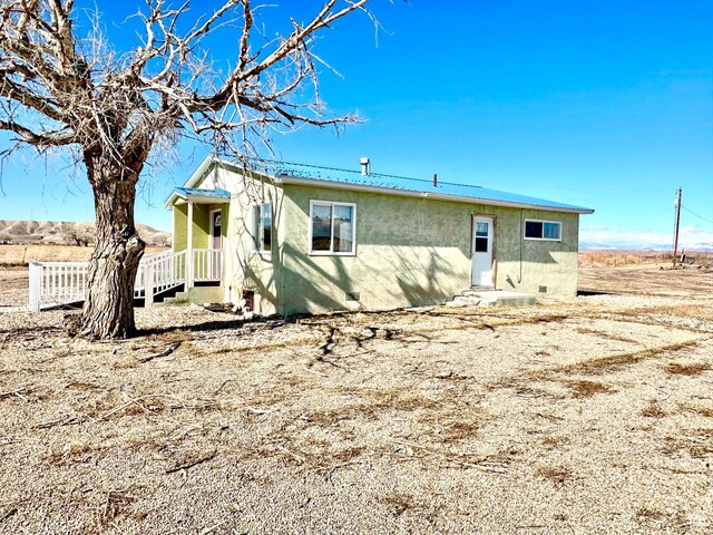 7998 E 5250 S, Randlett, UT 84063 - view of front of house featuring metal roof and stucco siding