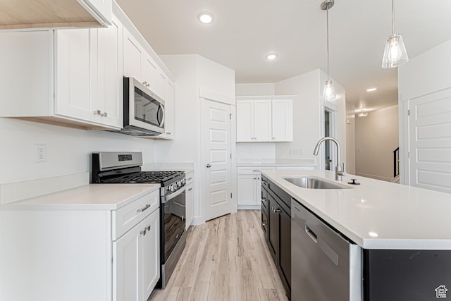 716 W 4500 S Unit 302, Mapleton, UT 84664 - kitchen featuring stainless steel appliances, a sink, light wood-type flooring, white cabinets, and a kitchen island with sink