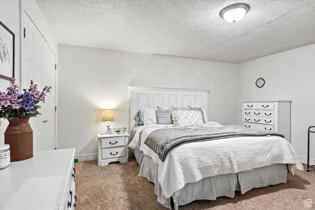 carpeted bedroom with a textured ceiling and baseboards