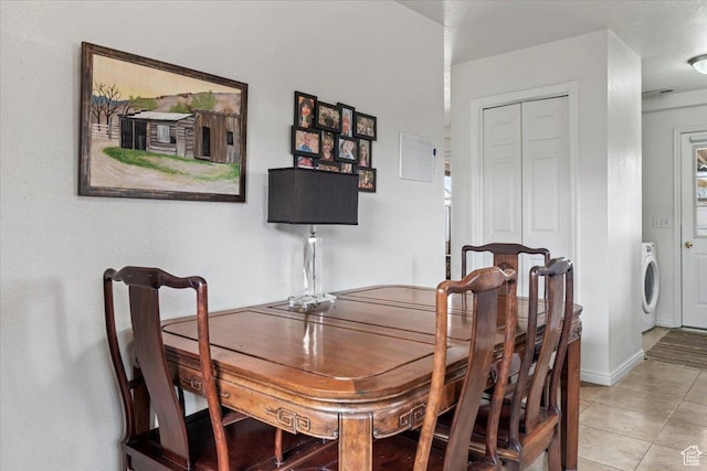 dining area with washer / dryer, light tile patterned floors, and baseboards