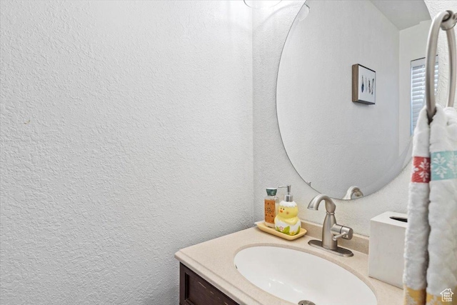 bathroom with a textured wall and vanity