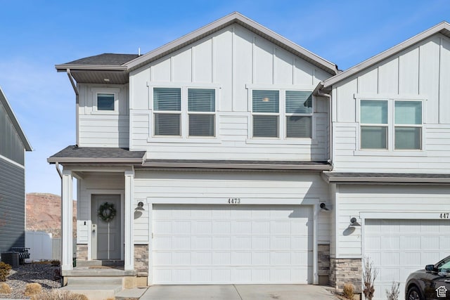 4473 E Hurstbourne Dr, Eagle Mountain, UT 84005 - view of front of property with board and batten siding, stone siding, driveway, and a garage