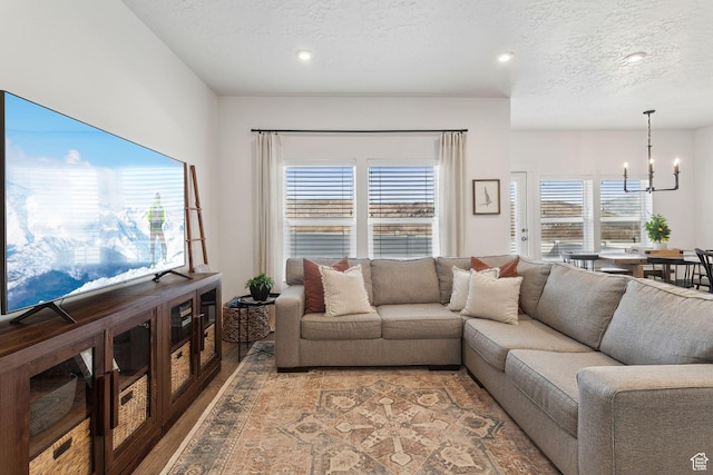 4473 E Hurstbourne Dr, Eagle Mountain, UT 84005 - living room with a wealth of natural light, a textured ceiling, a notable chandelier, and wood finished floors