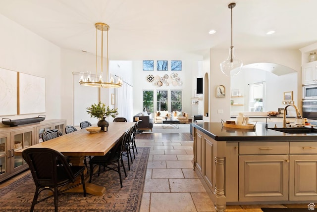 802 Leda Ln, Santa Clara, UT 84765 - kitchen featuring stone tile floors, a sink, open floor plan, dark countertops, and a center island with sink