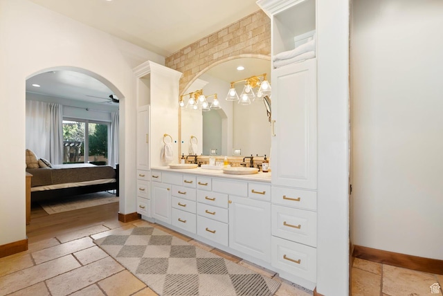 802 Leda Ln, Santa Clara, UT 84765 - full bathroom featuring a sink, stone tile flooring, baseboards, and connected bathroom