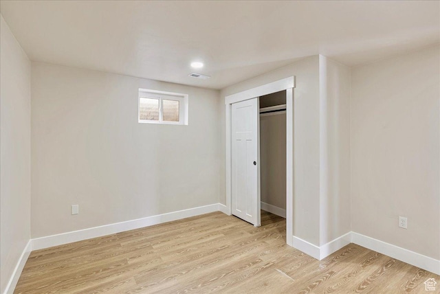 unfurnished bedroom with baseboards, a closet, visible vents, and light wood-style floors