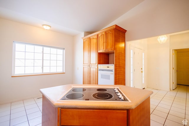524 S Oak Ln W Unit 3, Tooele, UT 84074 - kitchen with light tile patterned floors, lofted ceiling, white appliances, a kitchen island, and light countertops