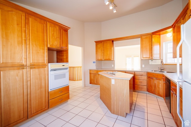 524 S Oak Ln W Unit 3, Tooele, UT 84074 - kitchen featuring white appliances, light tile patterned floors, a kitchen island, light countertops, and a sink