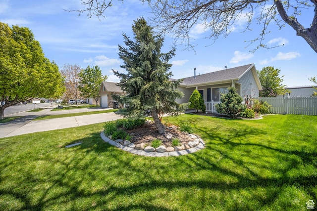 exterior space with fence, an attached garage, and driveway