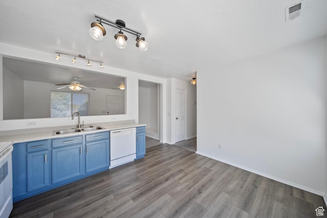 kitchen with white appliances, wood finished floors, a sink, and blue cabinets