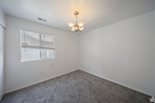 spare room featuring carpet flooring, a chandelier, baseboards, and visible vents