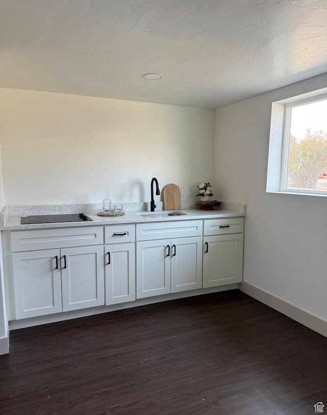 bar with baseboards, black electric stovetop, dark wood-style flooring, and a sink