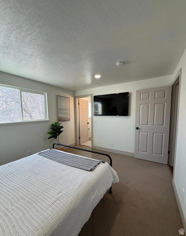 carpeted bedroom featuring baseboards and a textured ceiling