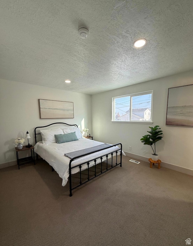 carpeted bedroom featuring recessed lighting, visible vents, a textured ceiling, and baseboards