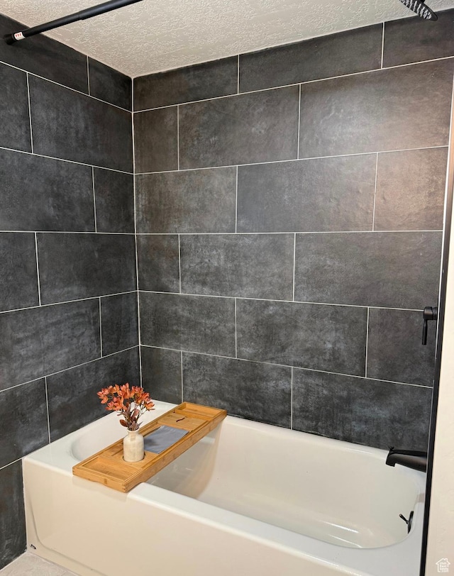 full bathroom featuring a textured ceiling and  shower combination
