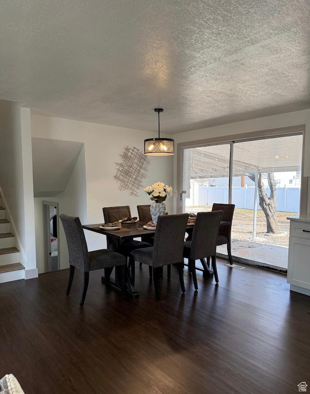 dining space with stairway, dark wood finished floors, and a textured ceiling