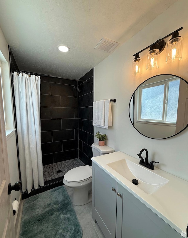 bathroom with visible vents, a shower stall, toilet, and vanity